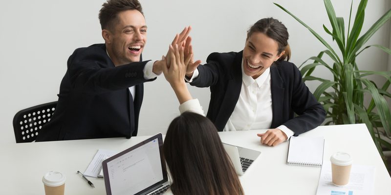 Excited millennial office team giving high five together, teambu lam xuat nhap khau